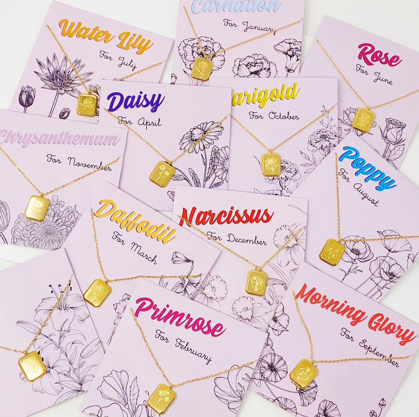 A collection of birth month flower pendant necklaces with gold-colored pendants and chain, each labeled with the corresponding month and flower name.