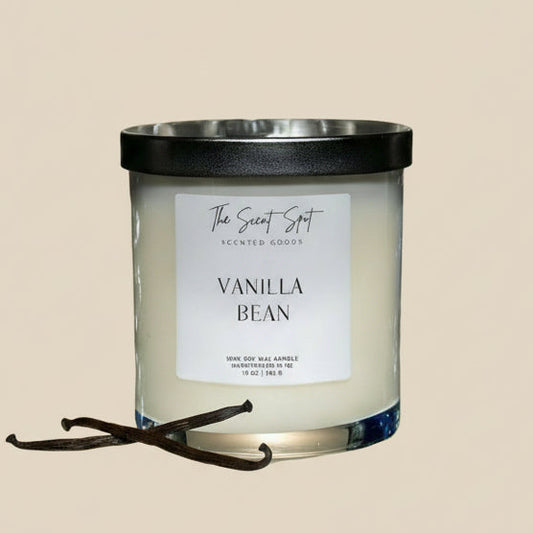 Vanilla bean scented candle with a black lid on a beige background